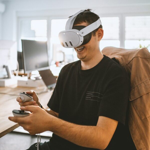 a man sitting at a desk wearing a virtual reality headset