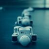 Vertical shot of white robots aligned on a dark surface, emphasizing technology.