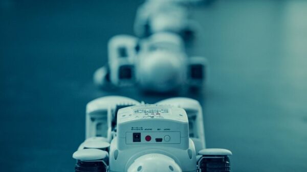 Vertical shot of white robots aligned on a dark surface, emphasizing technology.