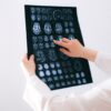 Doctor examines brain MRI scans closely for medical diagnosis in a hospital environment.