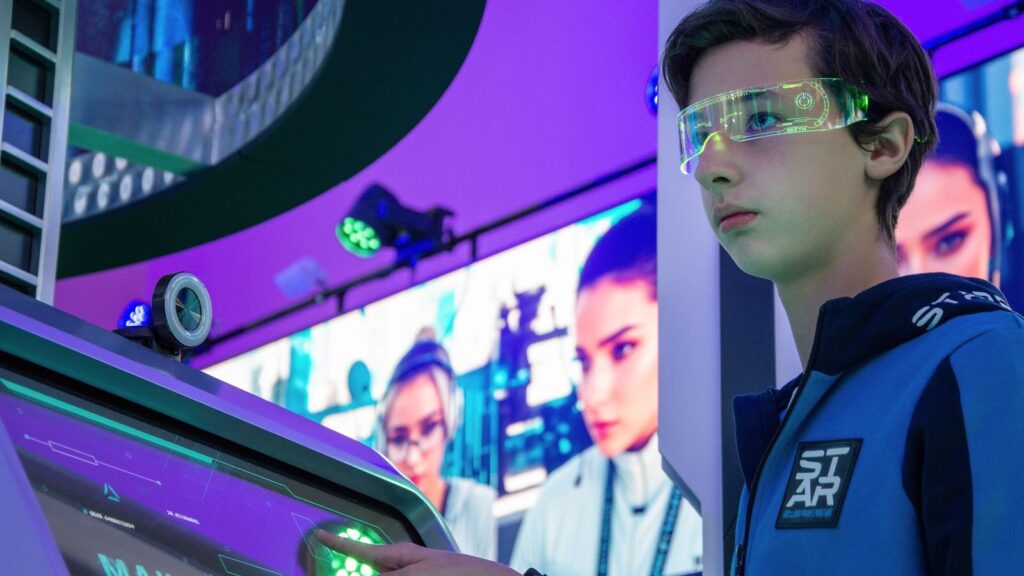 Teenager interacts with advanced touchscreen in a vibrant technology exhibition.