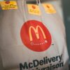 Paper packet with tasty fresh hot fast food on blurred background in restaurant