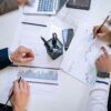 Business team analyzing financial charts and graphs during a collaborative meeting.