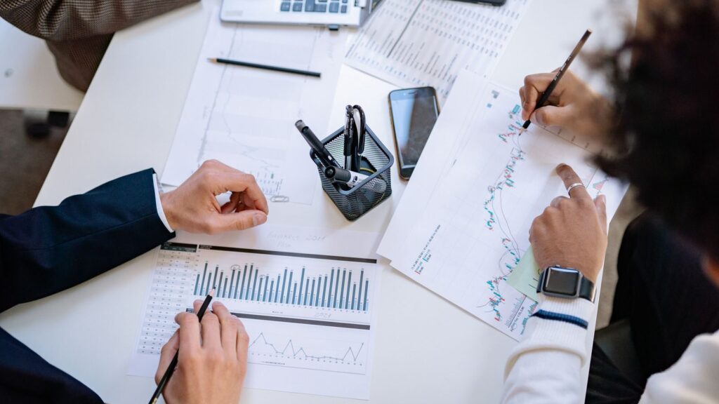 Business team analyzing financial charts and graphs during a collaborative meeting.