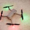 Overhead view of a modern drone with LED lights on a textured surface.