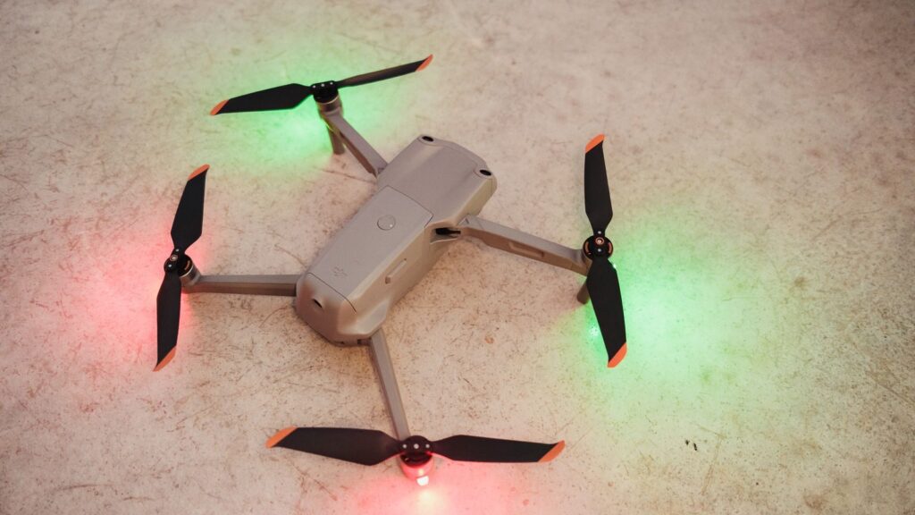 Overhead view of a modern drone with LED lights on a textured surface.