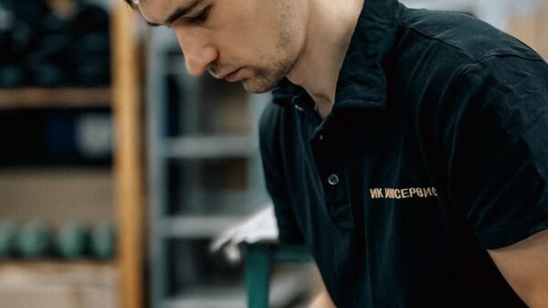 Male worker using a tablet in a warehouse, reflecting productivity and technology integration.