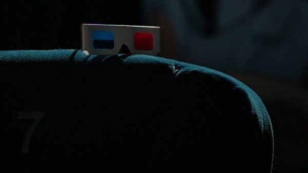 A dimly lit cinema featuring a pair of 3D glasses on a theater seat, capturing an immersive movie-going experience.