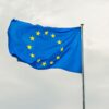 The European Union flag gracefully waving on a flagpole against a cloudy sky in Strasbourg, France.