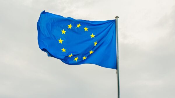 The European Union flag gracefully waving on a flagpole against a cloudy sky in Strasbourg, France.