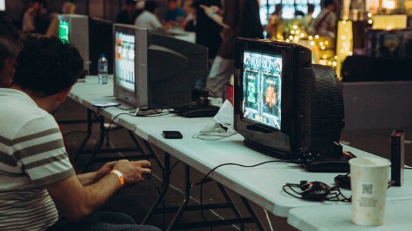 Adults enjoying a retro gaming event with CRT televisions and consoles, creating a nostalgic atmosphere indoors.