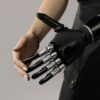 A futuristic black and chrome prosthetic arm being examined indoors, symbolizing technology integration.