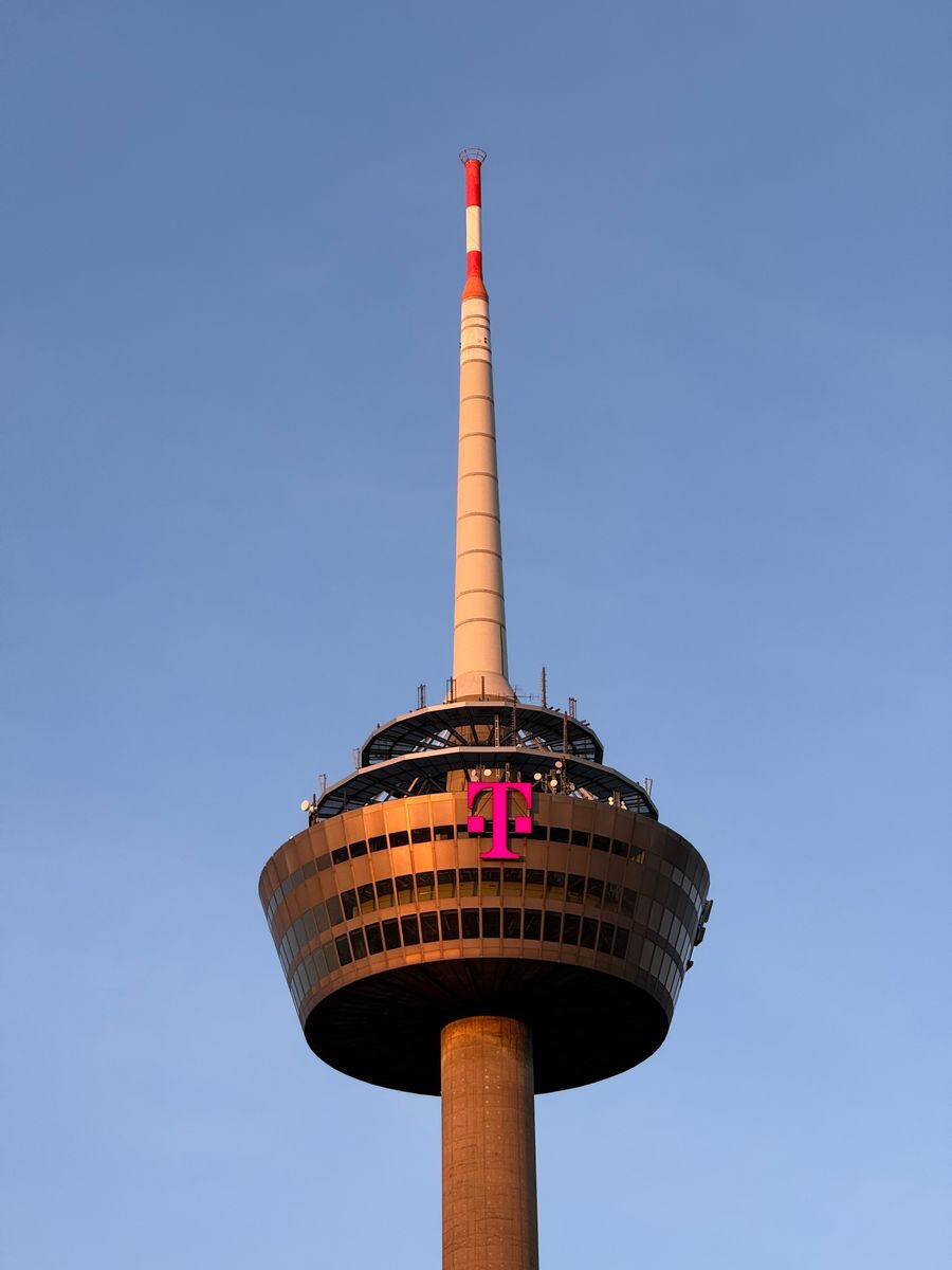 The Colonius tower in Cologne, Germany, captured at sunset against a clear sky.