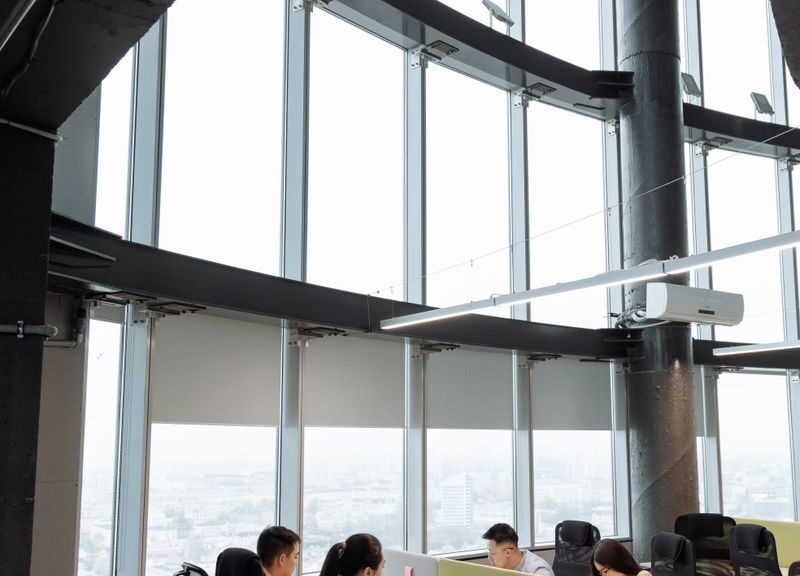 Spacious contemporary office space with employees working on laptops in a high-rise building.