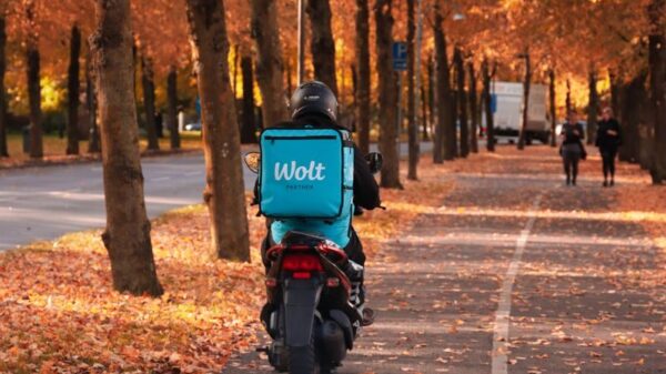 Motorbike delivery in autumnal Gothenburg with vibrant fall foliage.