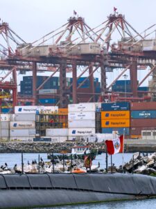 Busy shipping port in Callao, Peru with containers, cranes, and a Peruvian flag.