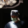 Focused surgeon in action under surgical lights during an operation in Istanbul, Türkiye.
