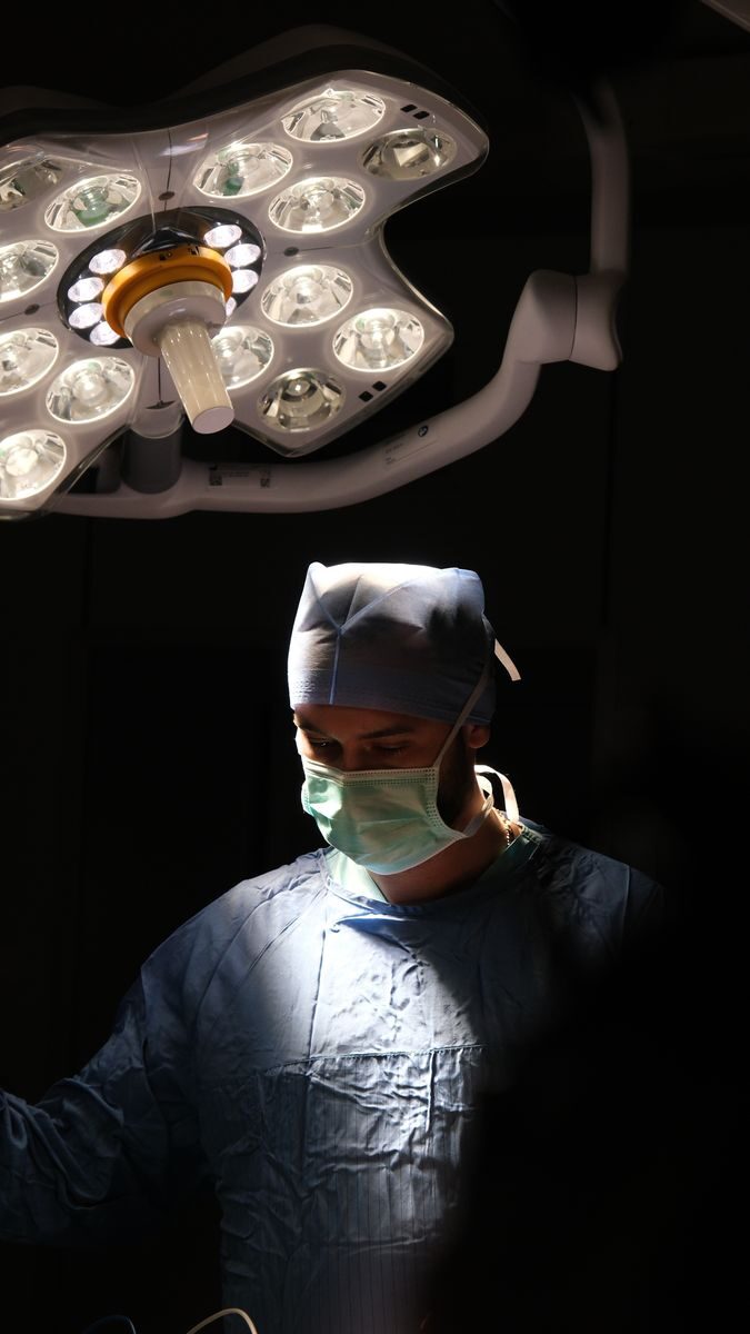 Focused surgeon in action under surgical lights during an operation in Istanbul, Türkiye.