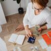 Top view of a woman managing finances with a calculator, cash, and bills in a home setting.