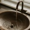 Water flowing into a bronze sink basin