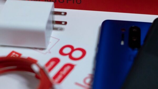Flat lay of OnePlus 8 Pro unboxing with smartphone and accessories on white background.