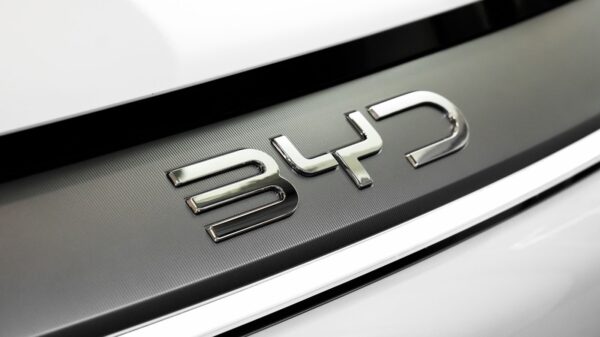 Detailed close-up of the chrome BYD logo on a car, showcasing sleek automotive branding.