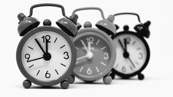 Monochrome image of three vintage alarm clocks highlighting the passage of time.