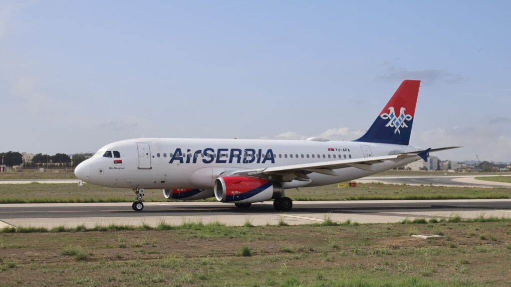 Air Serbia Airbus A320 on the runway ready for takeoff on a clear day.