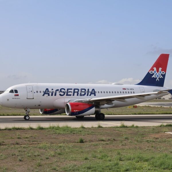 Air Serbia Airbus A320 on the runway ready for takeoff on a clear day.